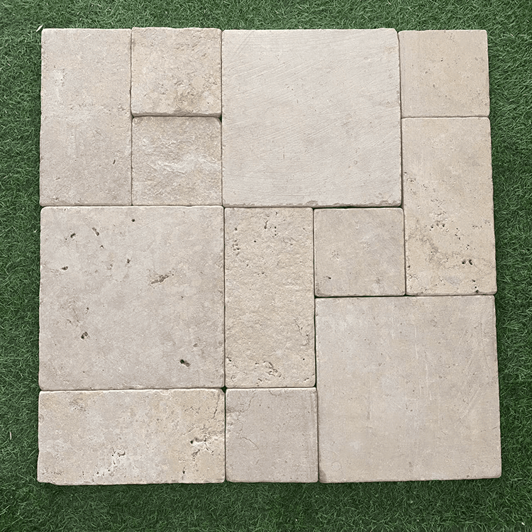  A pattern of square and rectangular travertine pavers arranged on grass, offering a rustic and natural design for outdoor spaces.