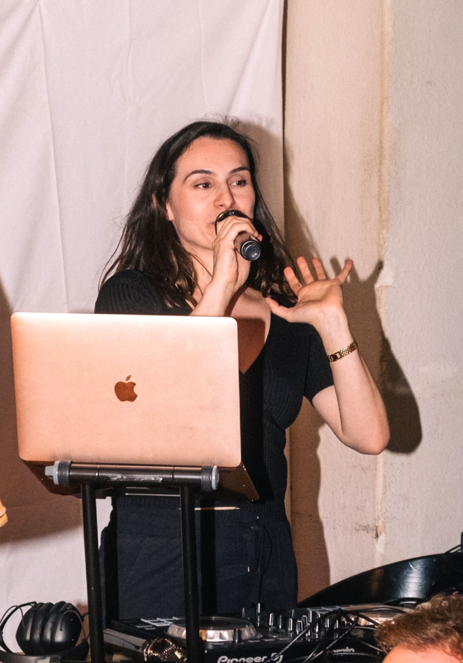 Woman talking on stage, holding microphone