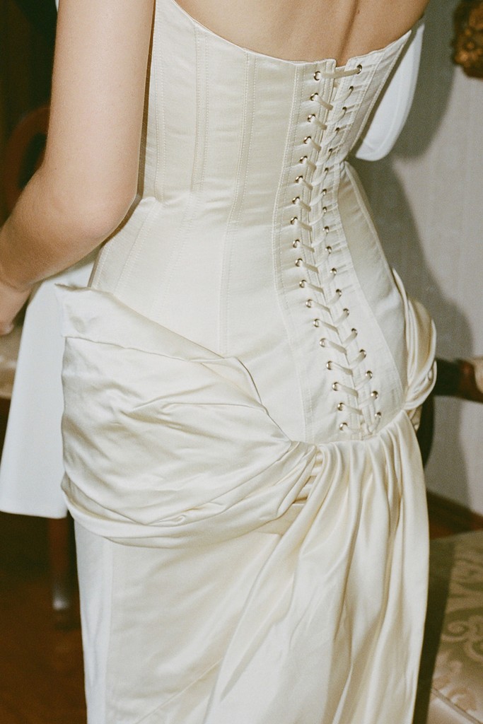 Close-up of a bride’s wedding dress with corset lacing and draped fabric