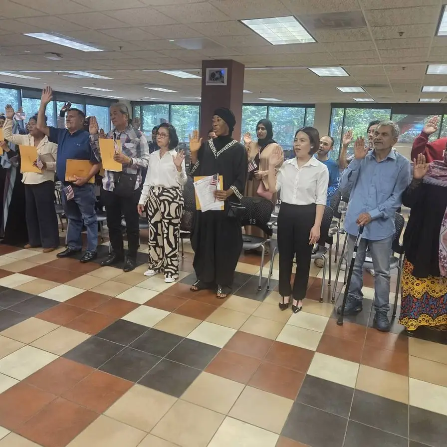 Ecstatic individual holding U.S. flag after naturalization, aided by Fibi Law