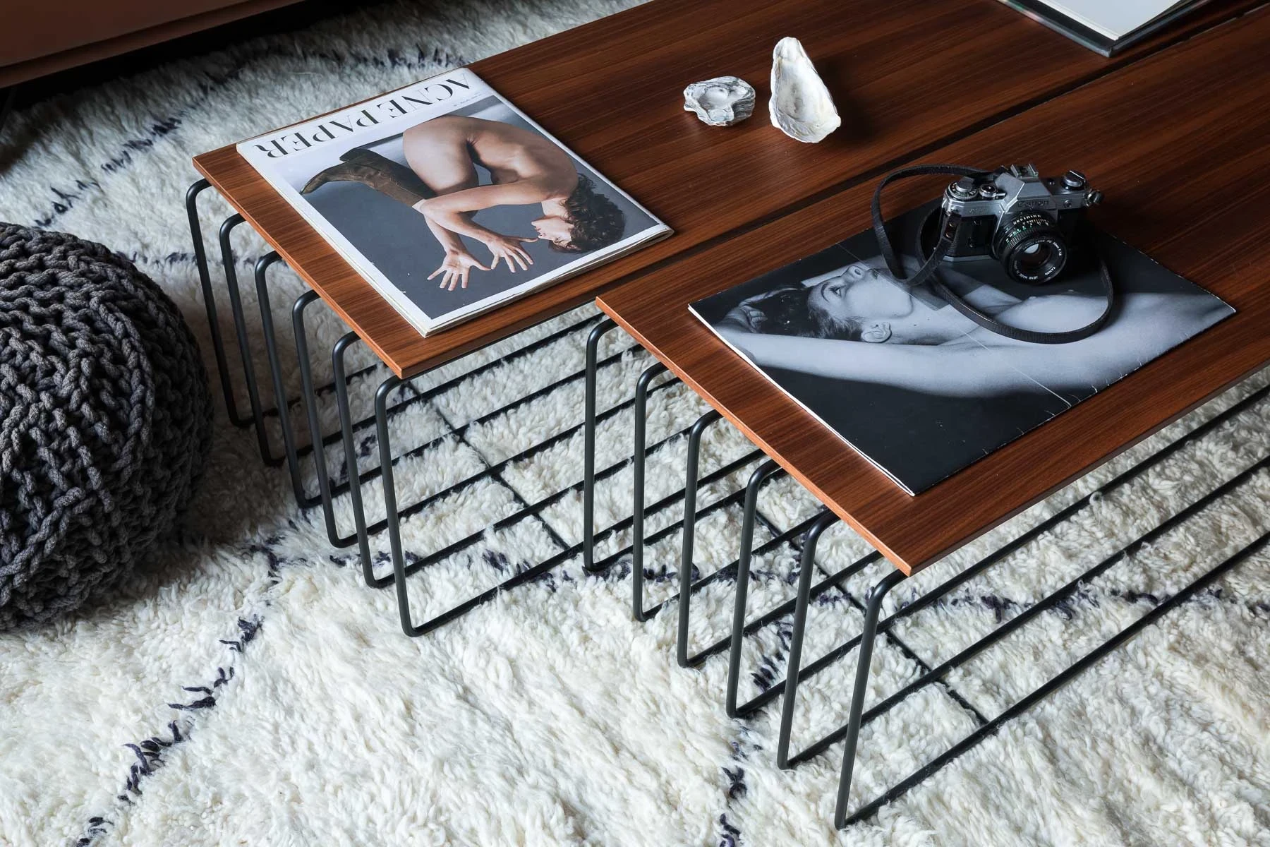 Revues posées sur tables design, tapis doux, bois et textures
