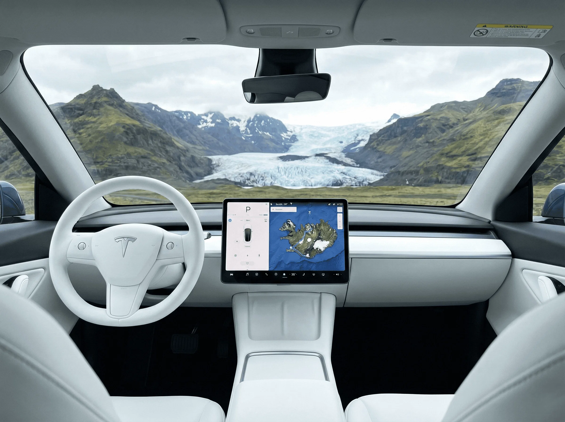 View from the driver's seat with a white interior looking out through the windshield at a glacier lagoon.