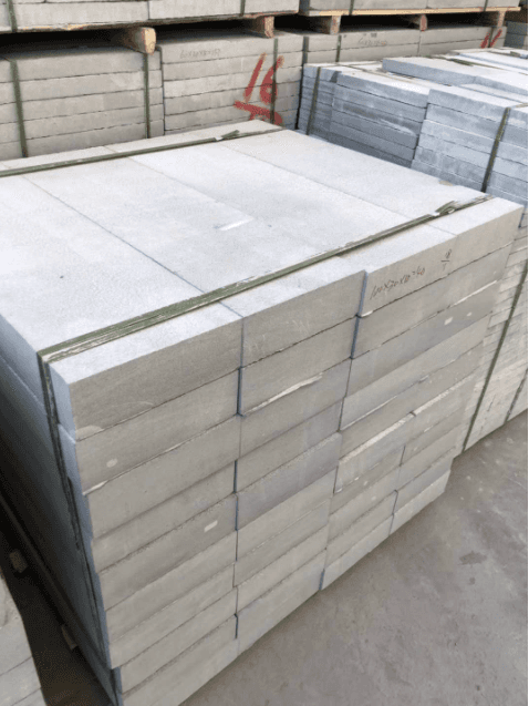 Stack of calibrated stone slabs produced by the continuous calibrating machine, ready for use in construction and design projects, demonstrating the machine's high processing precision.