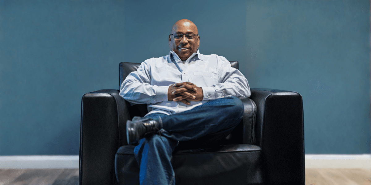 Man sitting confidently in black armchair, representing Roderick Robeson CPA LLC’s proactive tax strategy and financial planning expertise.