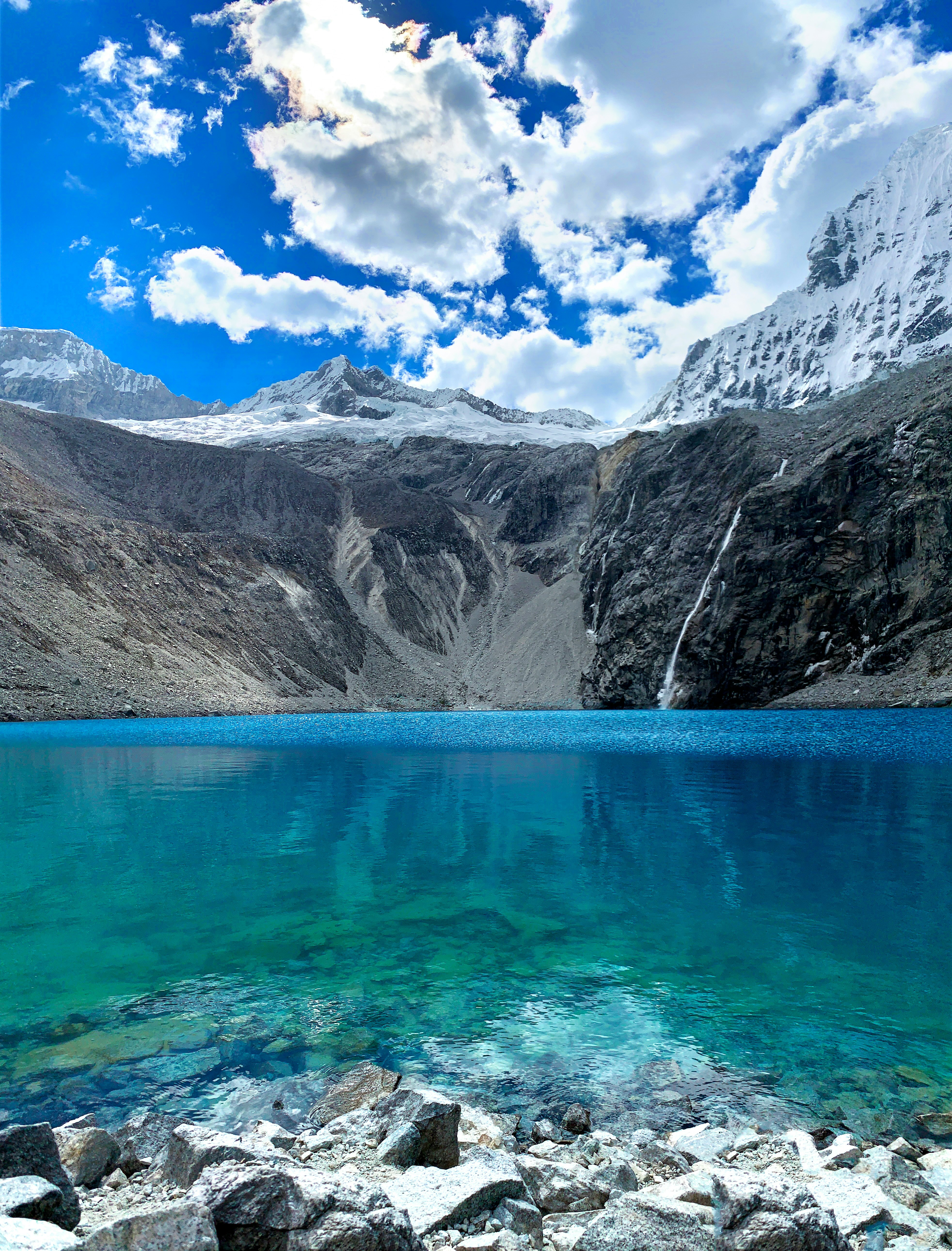 blue lake near gray mountain during daytime