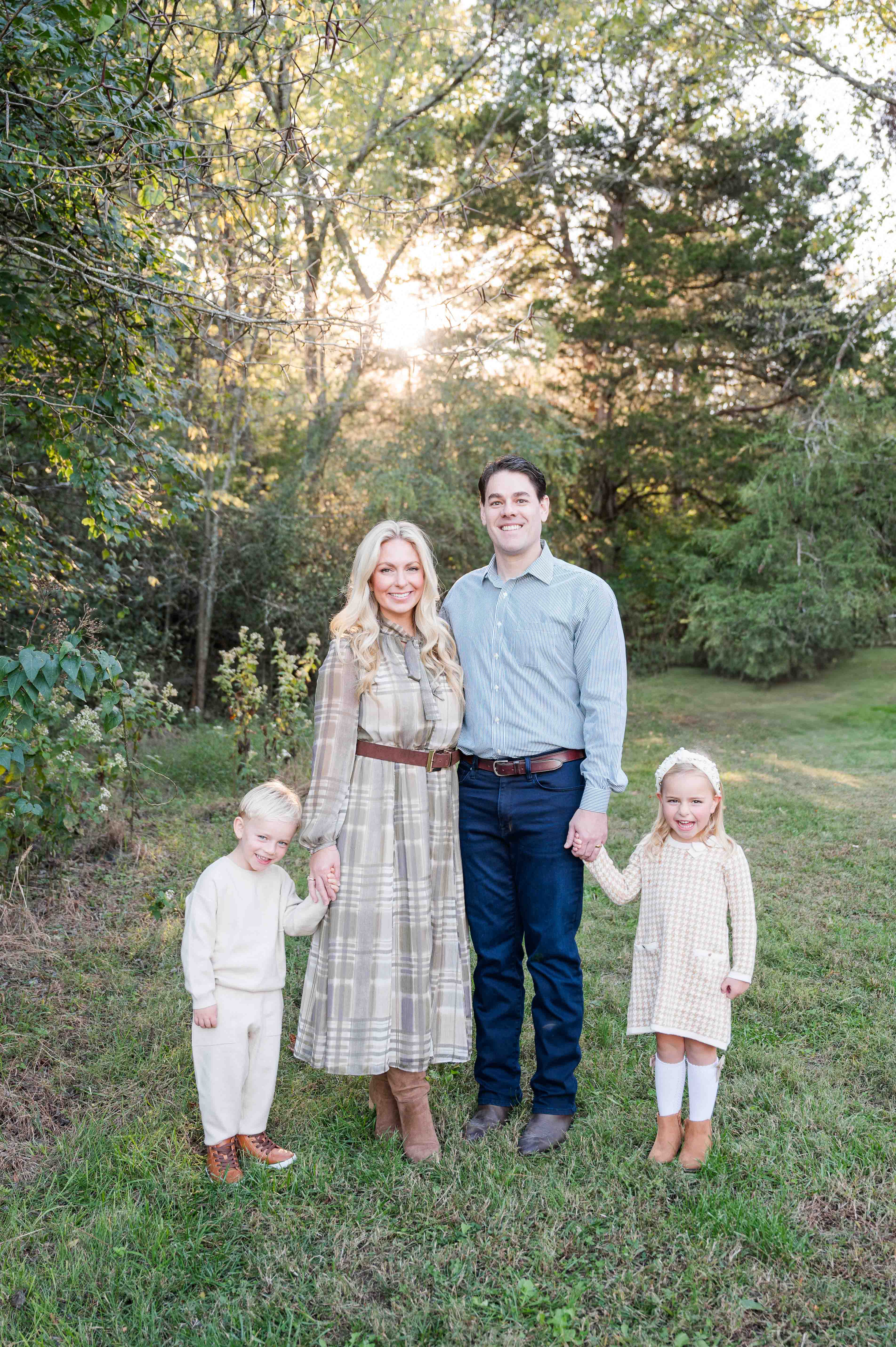 Family portrait in park with glowing light behind them.