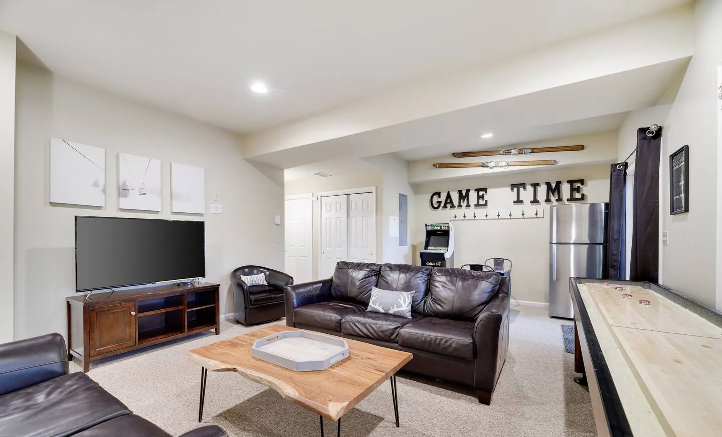 Lower level living room with leather sofas, smart TV and shuffleboard at Mountainwoods Memories