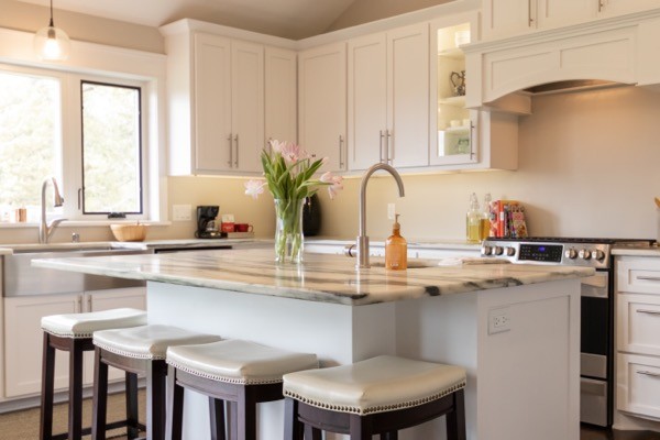 Kitchen island with barstools and white cabients