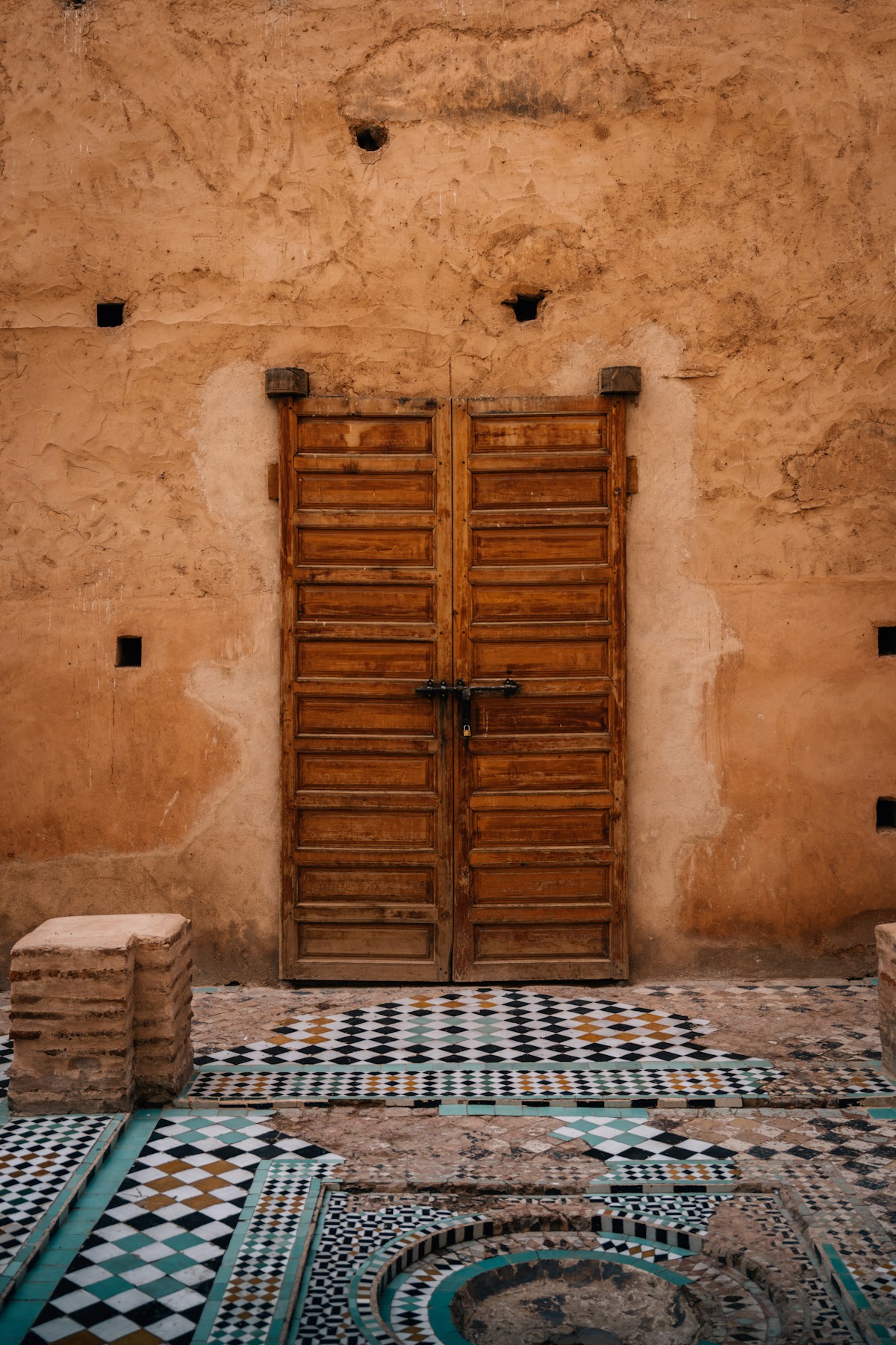 Wooden doors and ornate tilework in a Marrakech souk courtyard