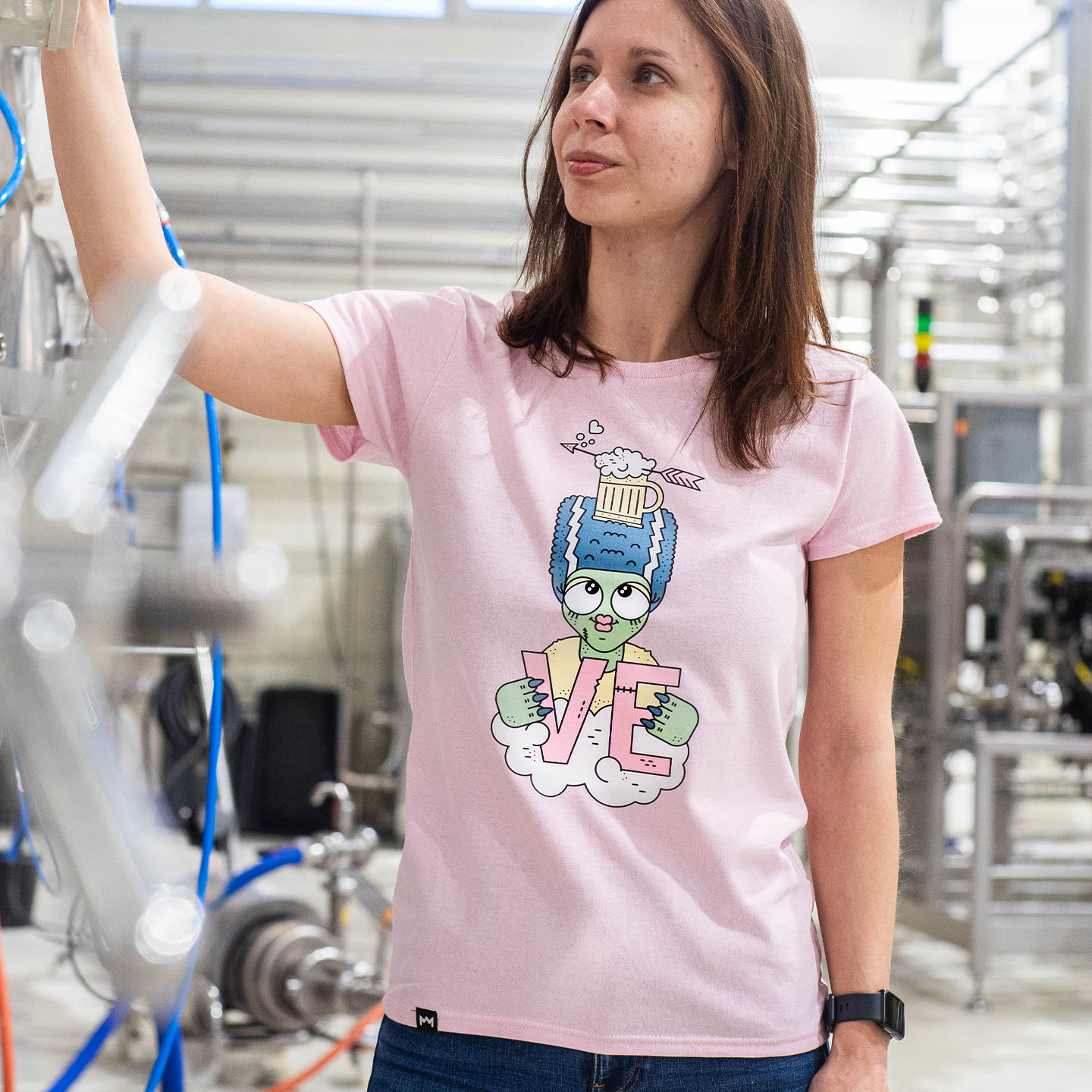 Woman in blue hat and sweater sitting on couch with laptop.