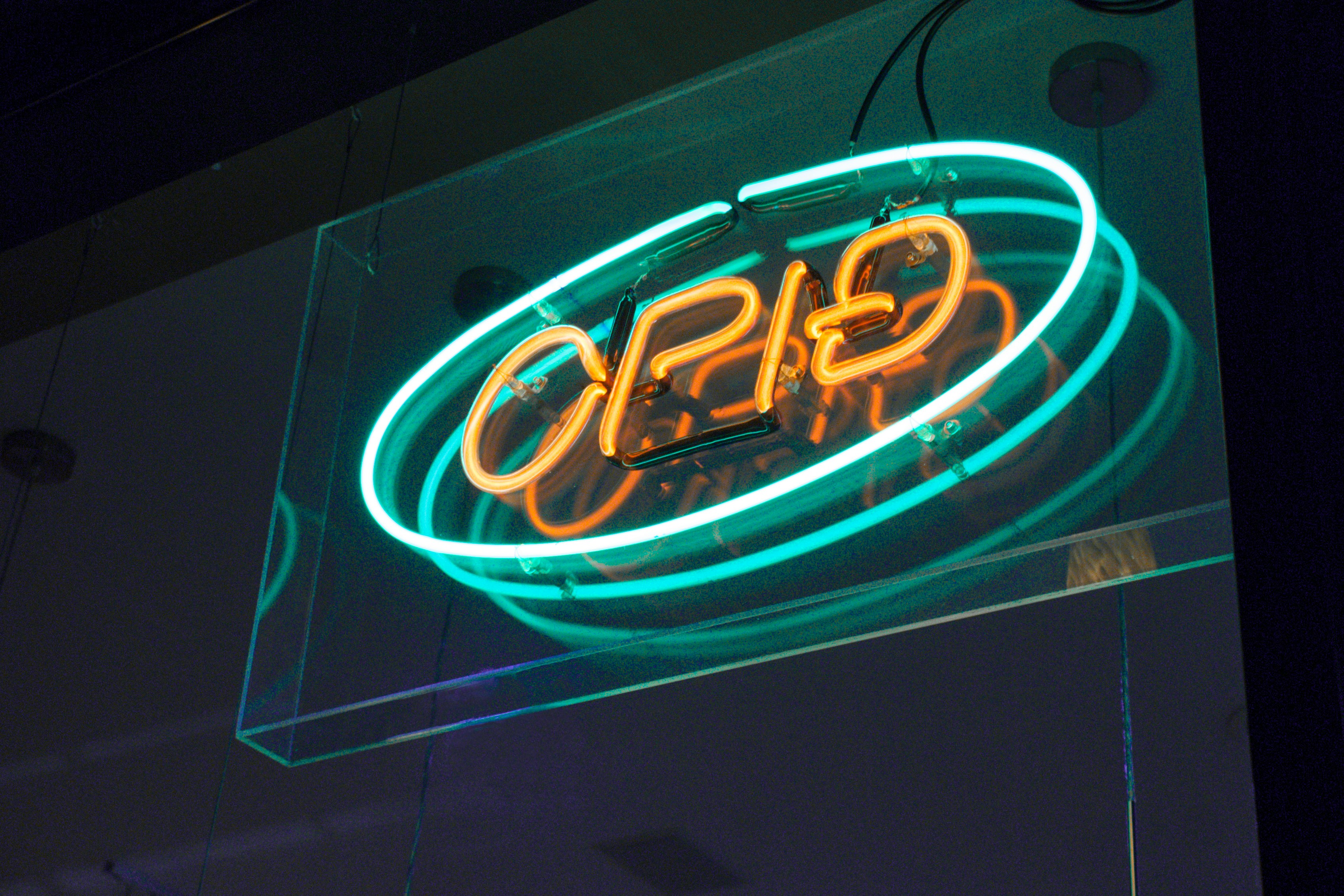 a neon sign hanging from the side of a building