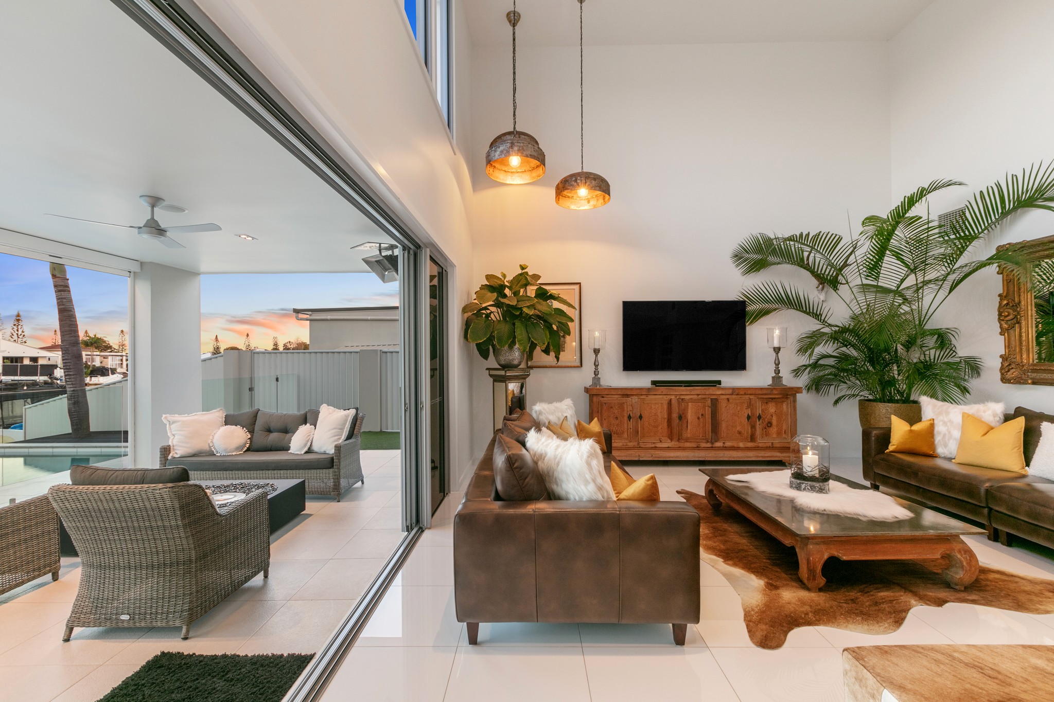 Bright, airy interior with arched doorways, wooden furniture, and a view of greenery outside.