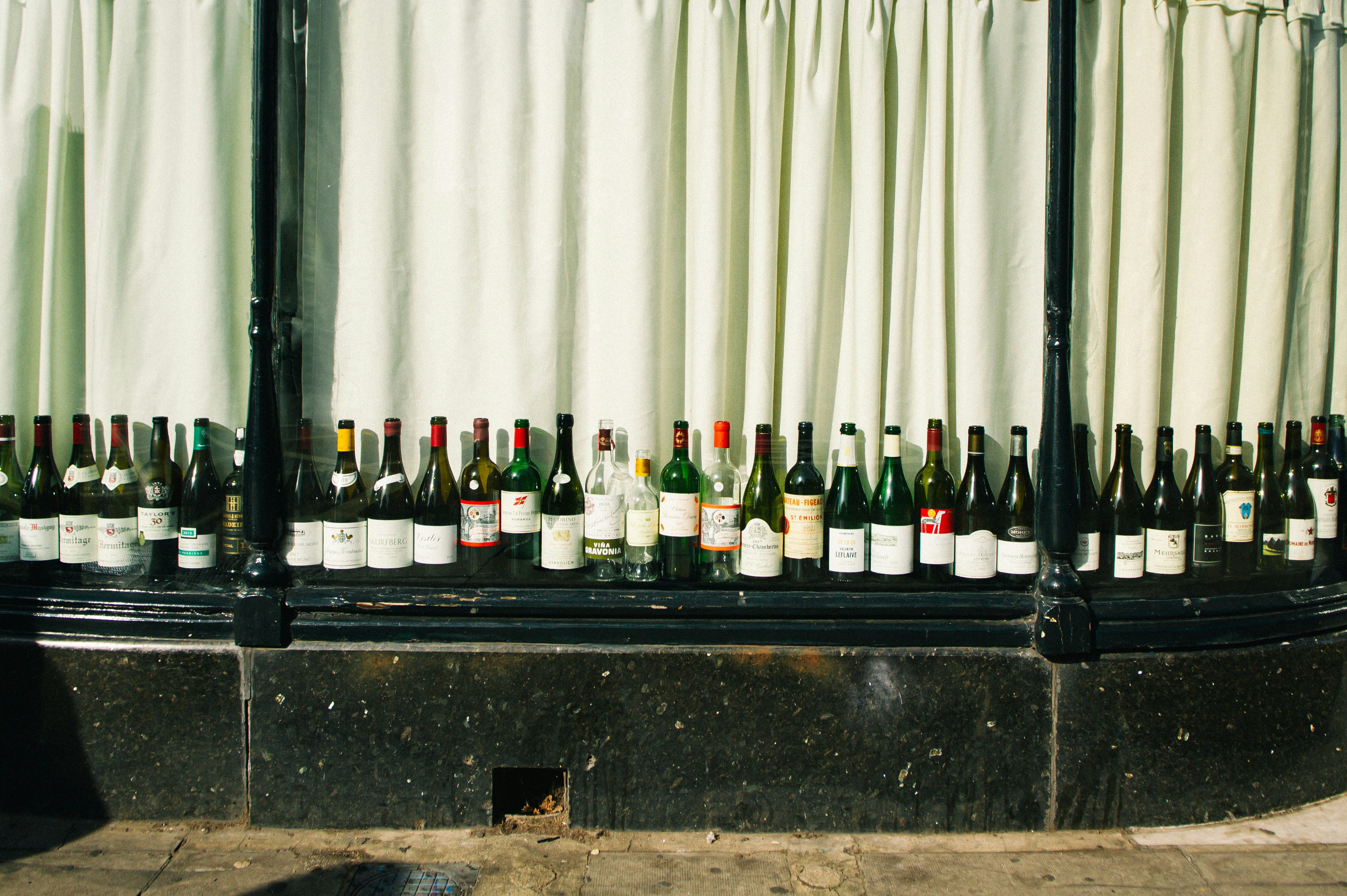 Row of wine bottles displayed in a window