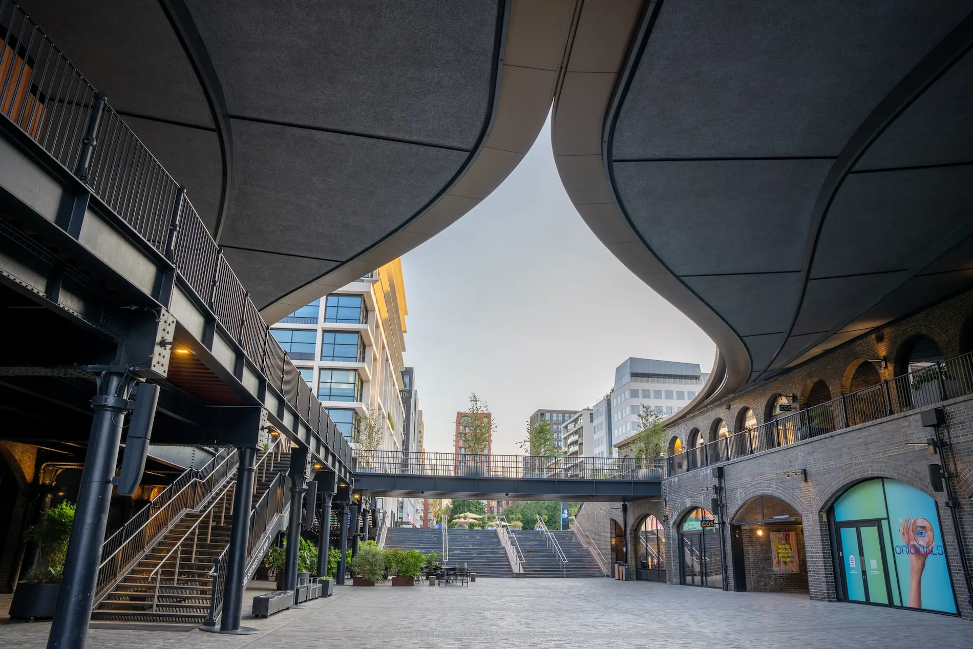 Low-angle aerial photography showcasing the modern curved roof architecture and walkways of a retail district