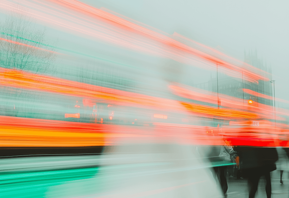 People walking through a dense fog, their silhouettes barely visible against the gray mist.