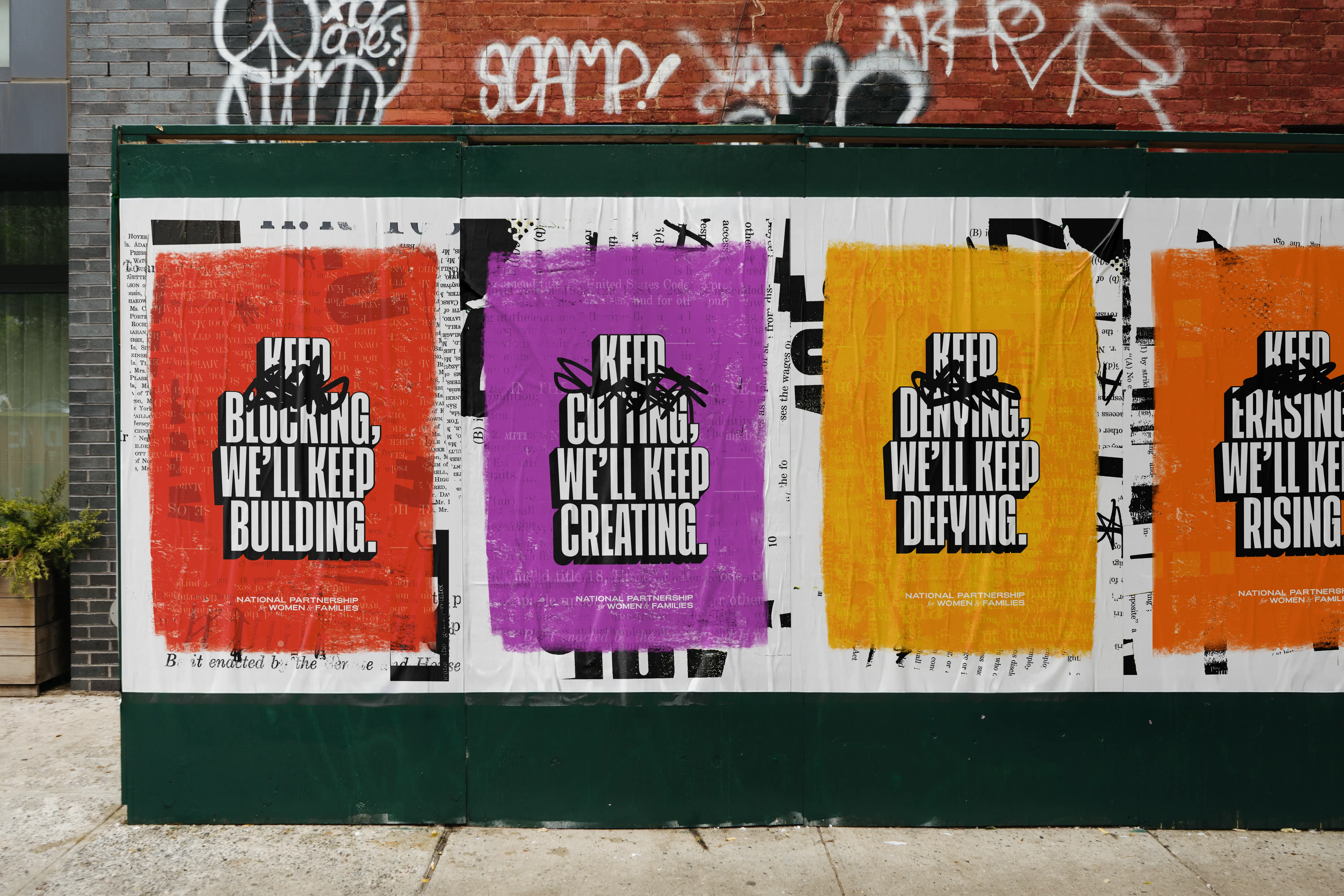 National Partnership campaign posters with bold messages on a street wall.