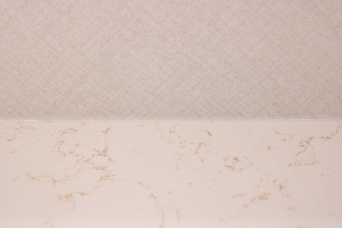 Image of KHD Homes luxurious interior design featuring elegant marble countertop and textured wall paneling detail.