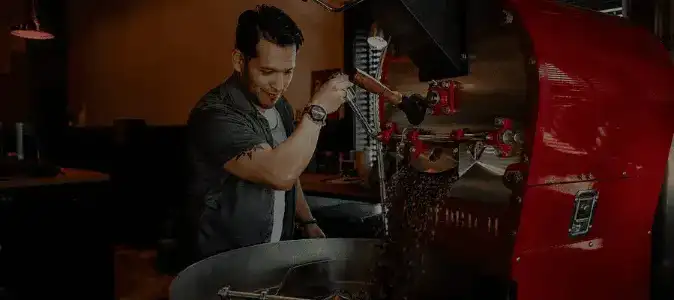 Barista at Pain d'Avignon roastery preparing small-batch coffee