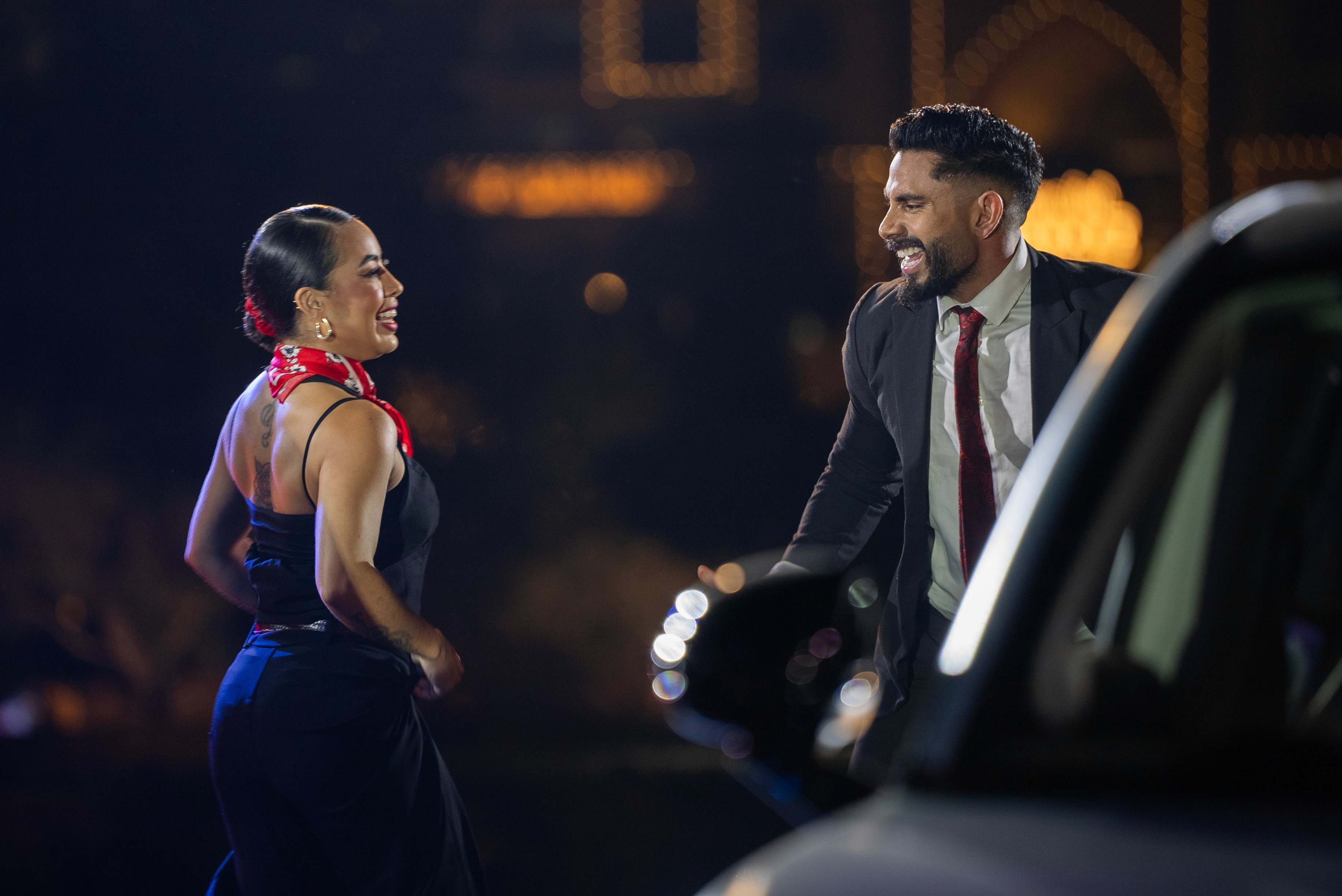 Business couple performers in formal costumes during smart car reveal flashmob in Dubai beside launch vehicle