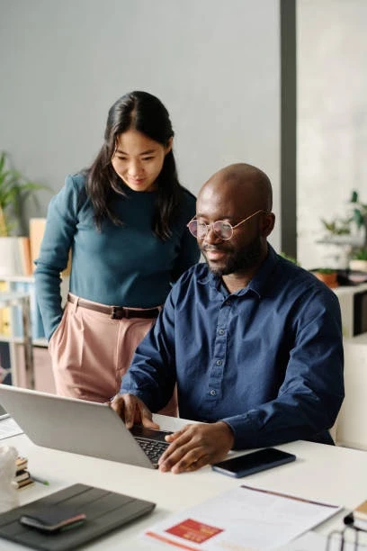 Co-workers choosing the right insurance option on a laptop