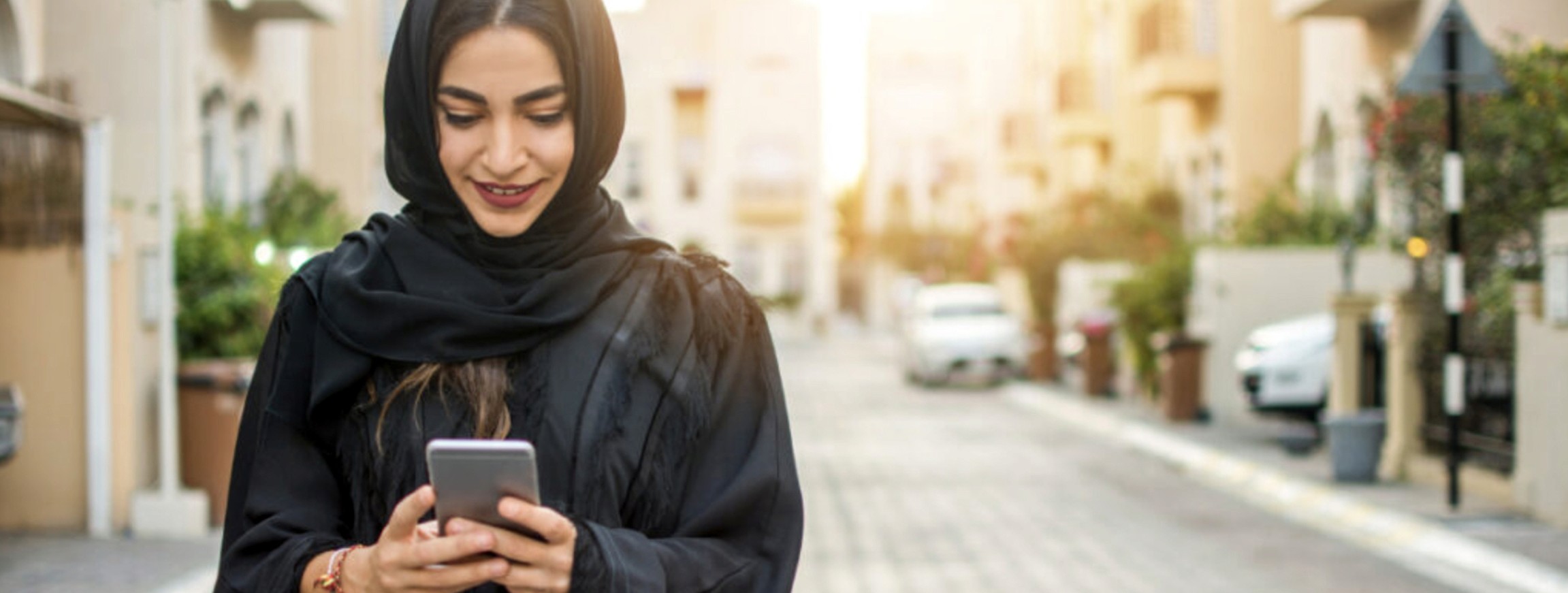 Professional woman engaging with digital technology in an urban environment, symbolizing connection and innovation.