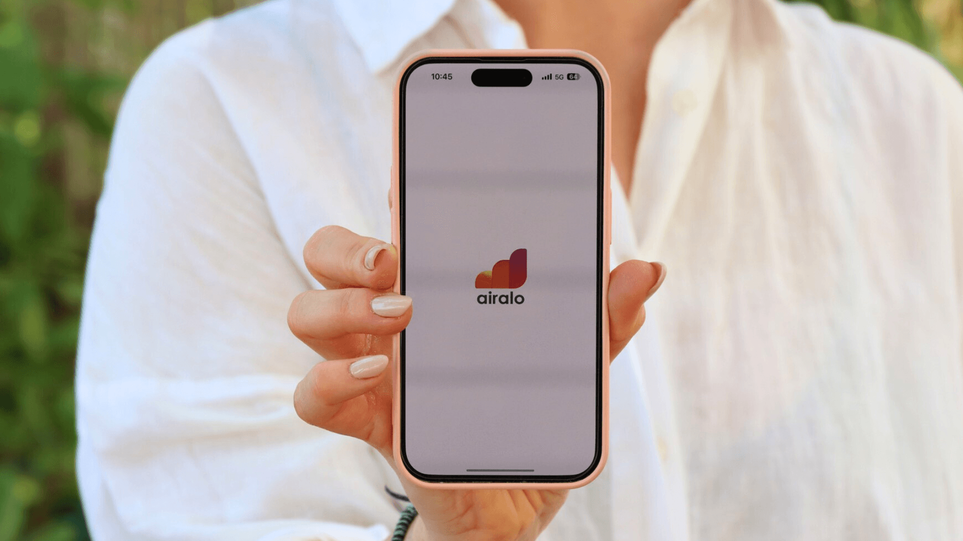 Person holding a smartphone displaying the Airalo app