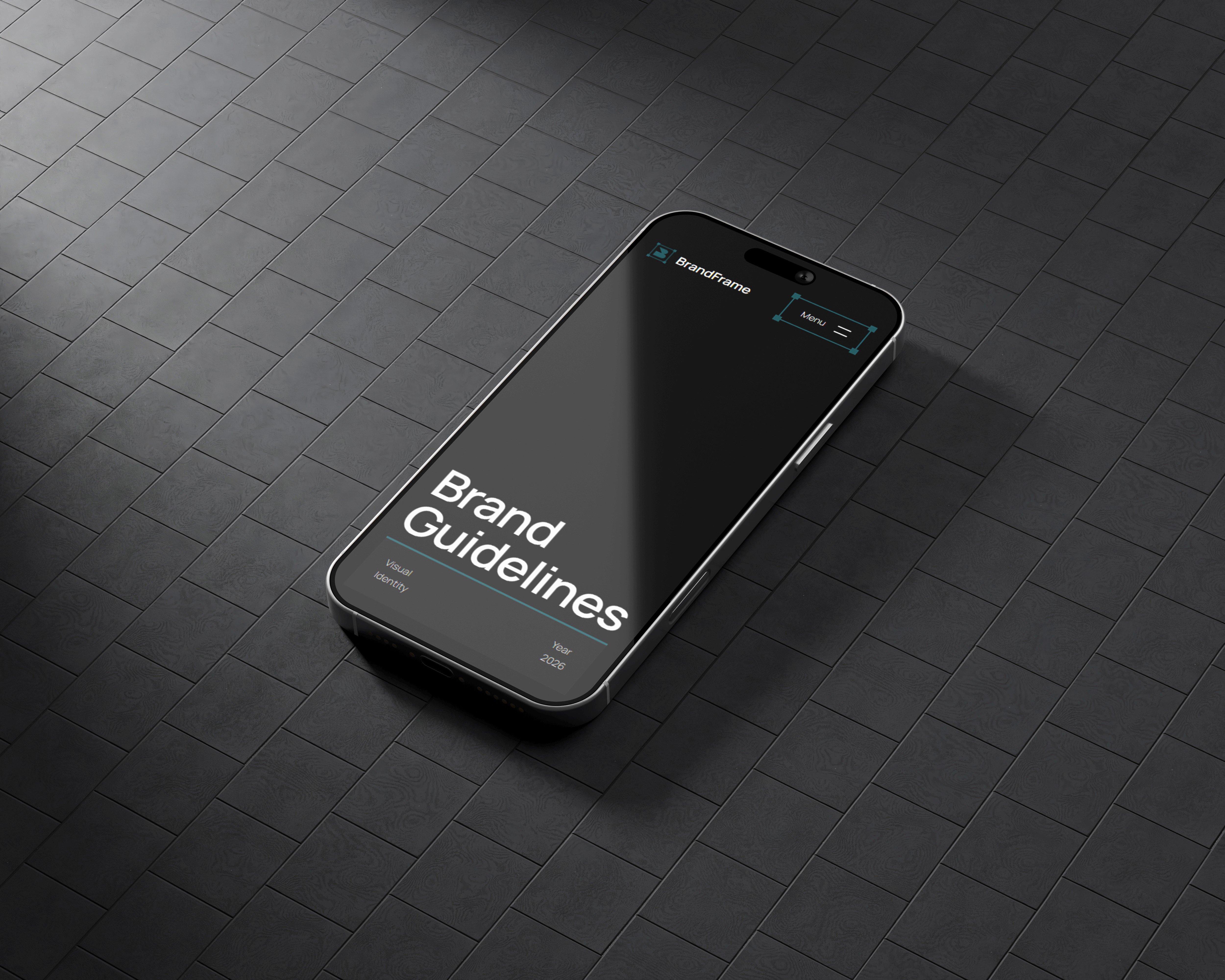 A high-angle shot of an iPhone resting on a dark, textured tiled surface. The screen displays the BrandFrame mobile interface with "Brand Guidelines" in bold white text, a simplified hamburger menu, and "Visual Identity 2026" branding, showcasing responsive web design.