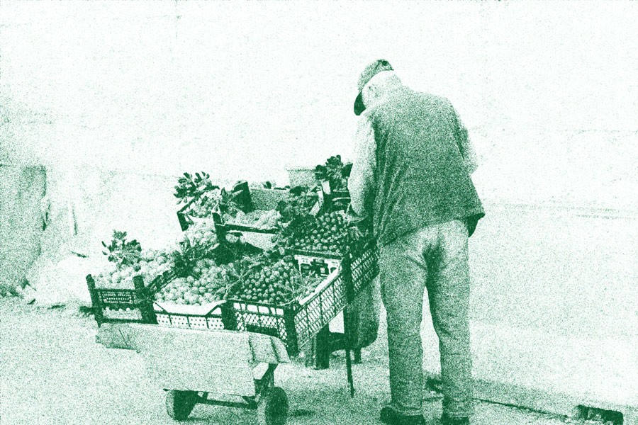 Local Older Man Oraganizing Food Market Stand With Fruit and Veggies