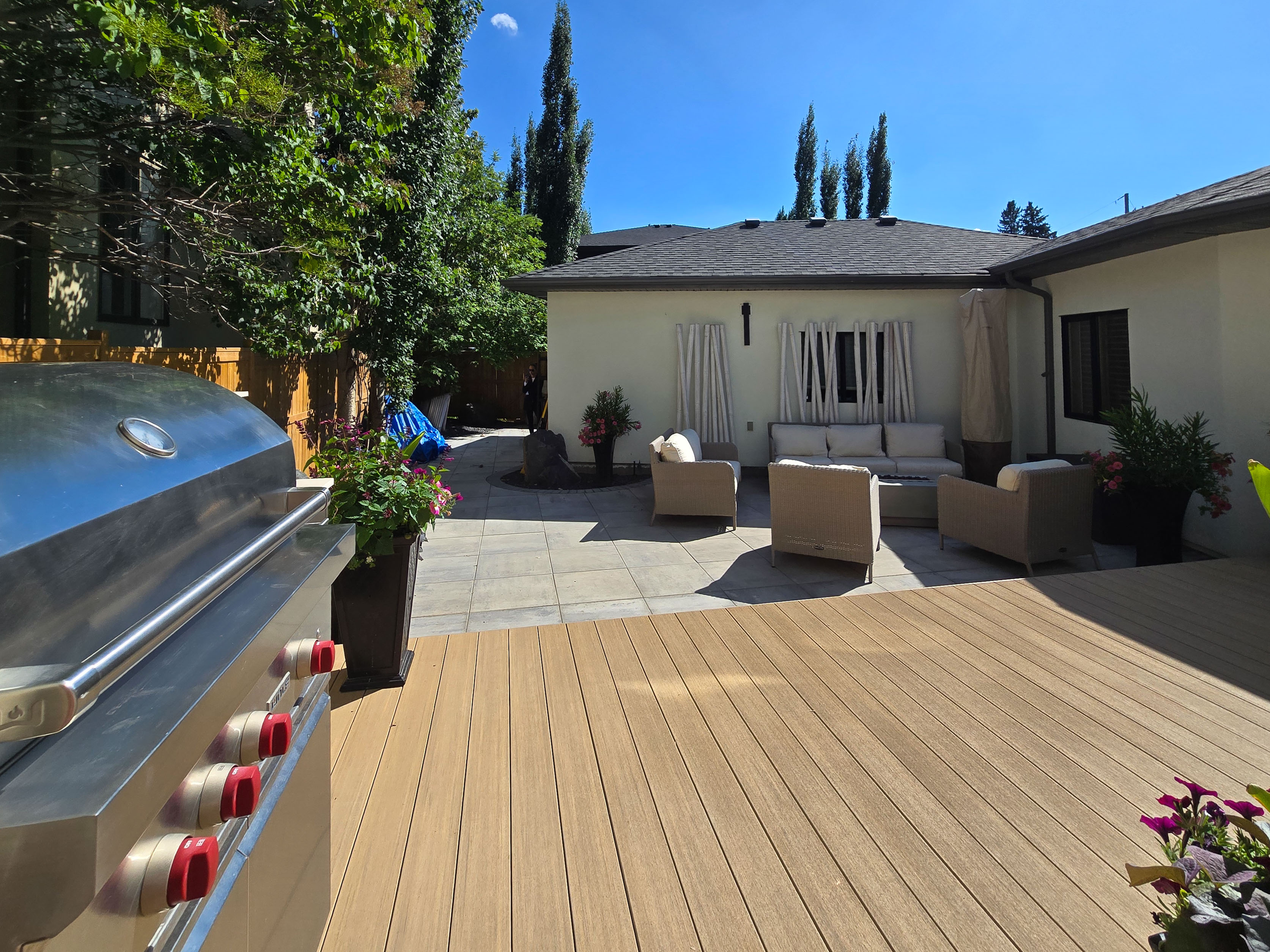 Image of KHD Homes outdoor living space with deck, patio furniture, grill, and landscaping design.