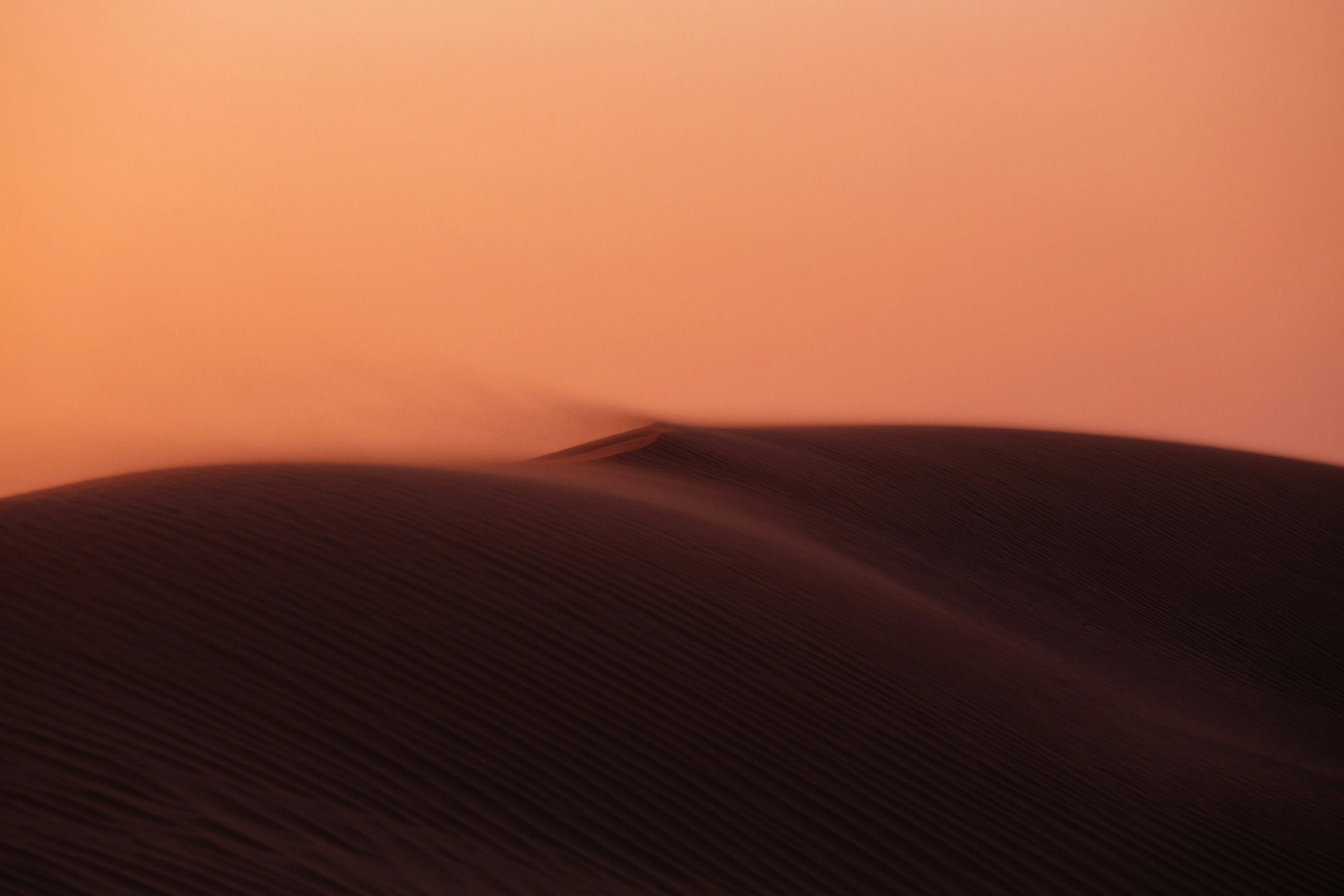 An aerial view of a sand dune during a dust storm.