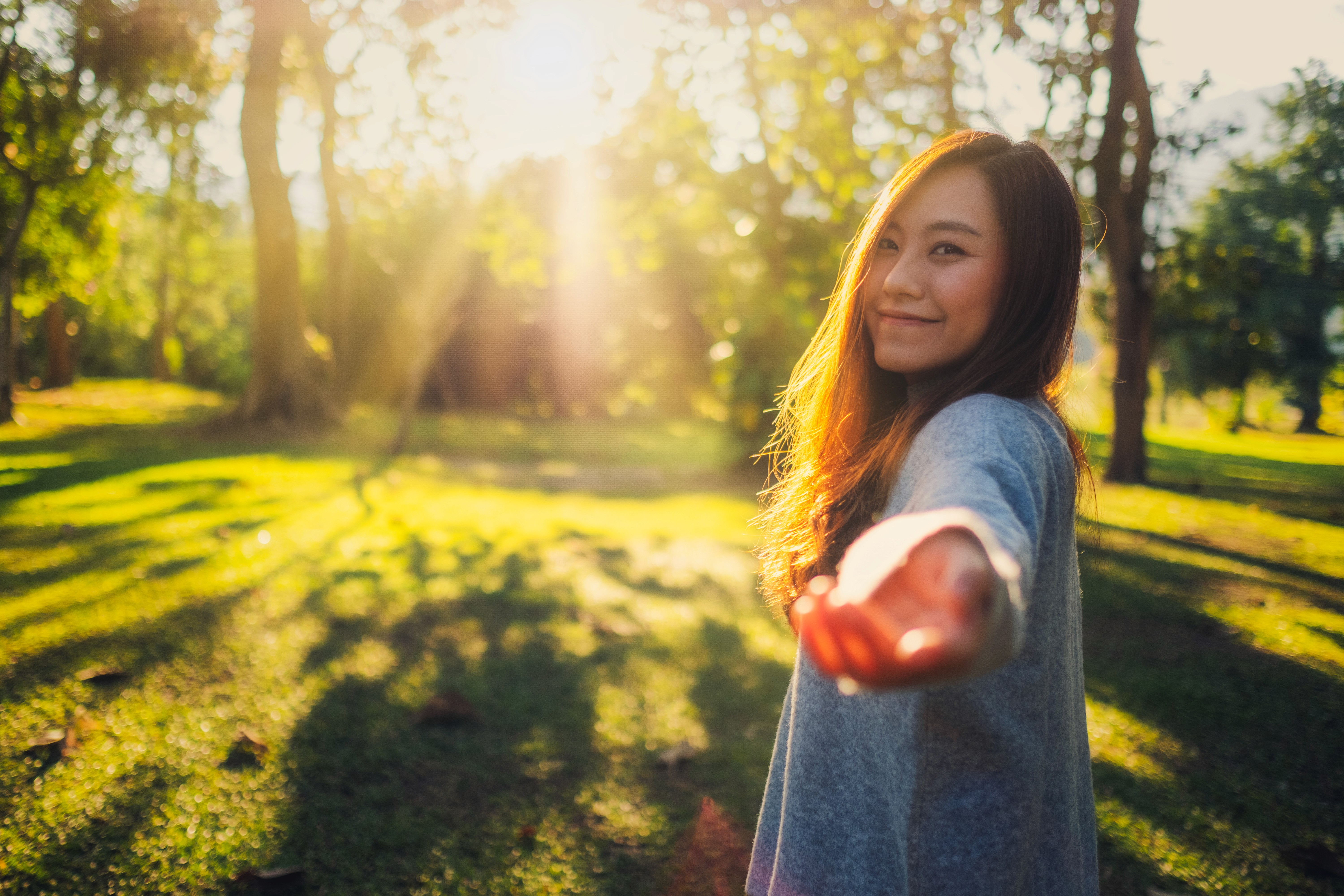 Happy woman enjoying sunshine in a park