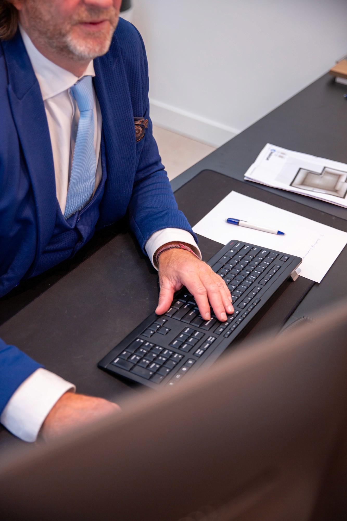 Two colleagues smiling while working together on a laptop.