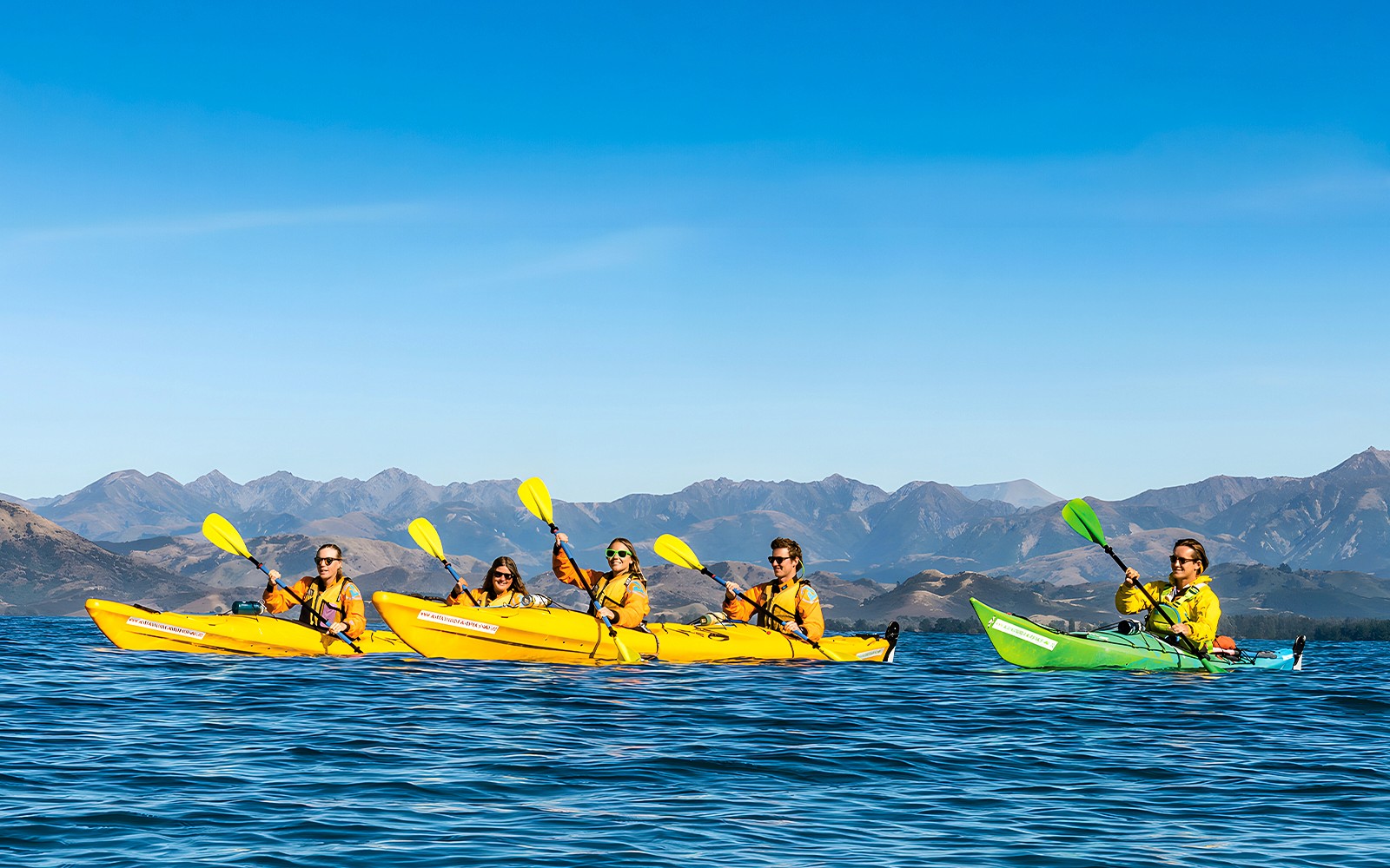 Gruppenkajak auf einer geführten Wildtier-Tour mit Bergblick im Hintergrund.