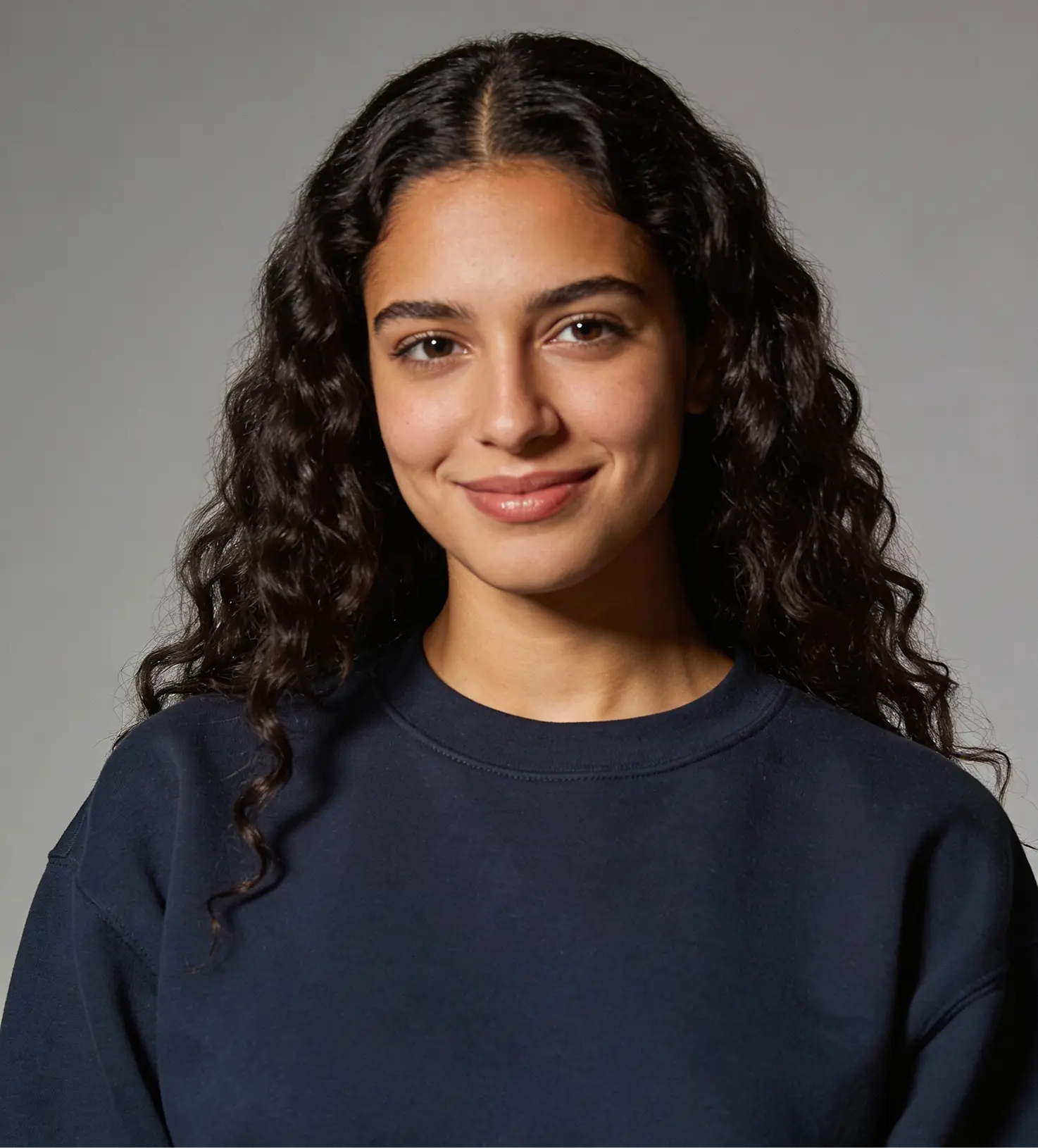a young brown woman with long hair wearing navy-blue hoodie with a smiley face