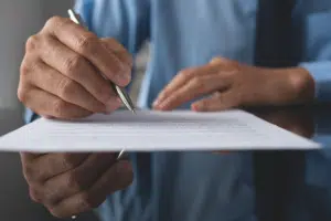 Pessoa escrevendo em uma folha
