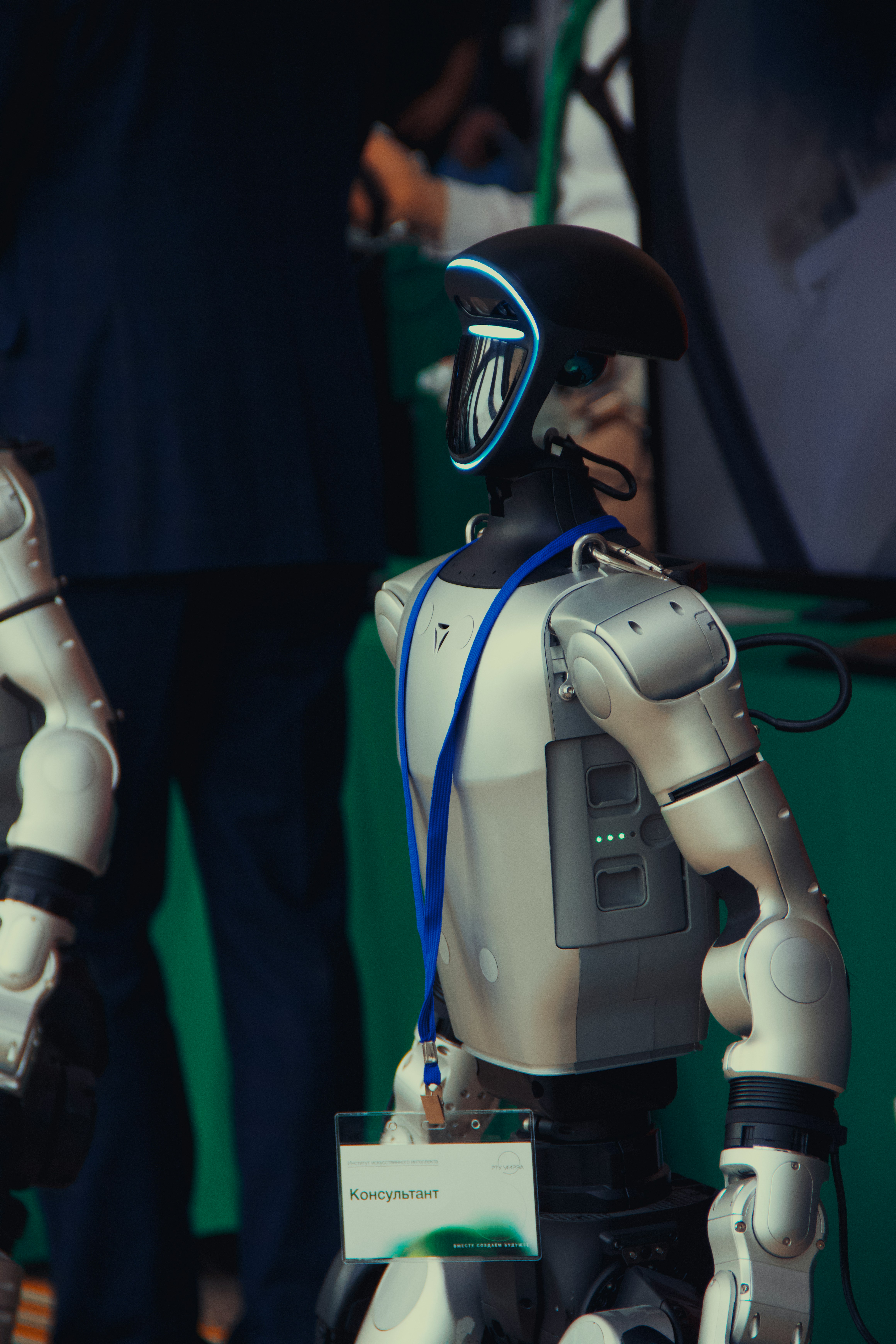 A humanoid robot with a blue lanyard and badge.