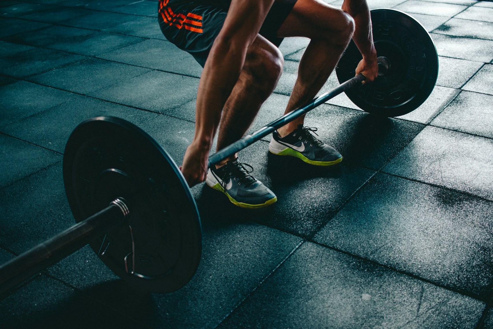 Close-up of an athlete performing a heavy barbell deadlift in a gym, representing raw strength and power.