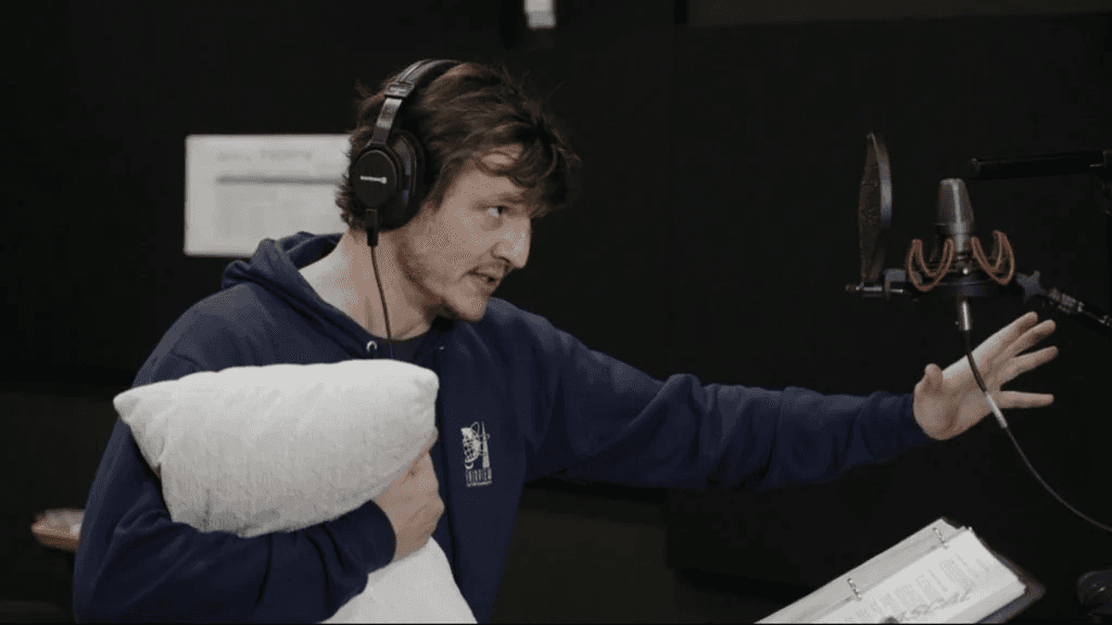 Person in headphones holds a pillow while recording vocals in a sound studio.