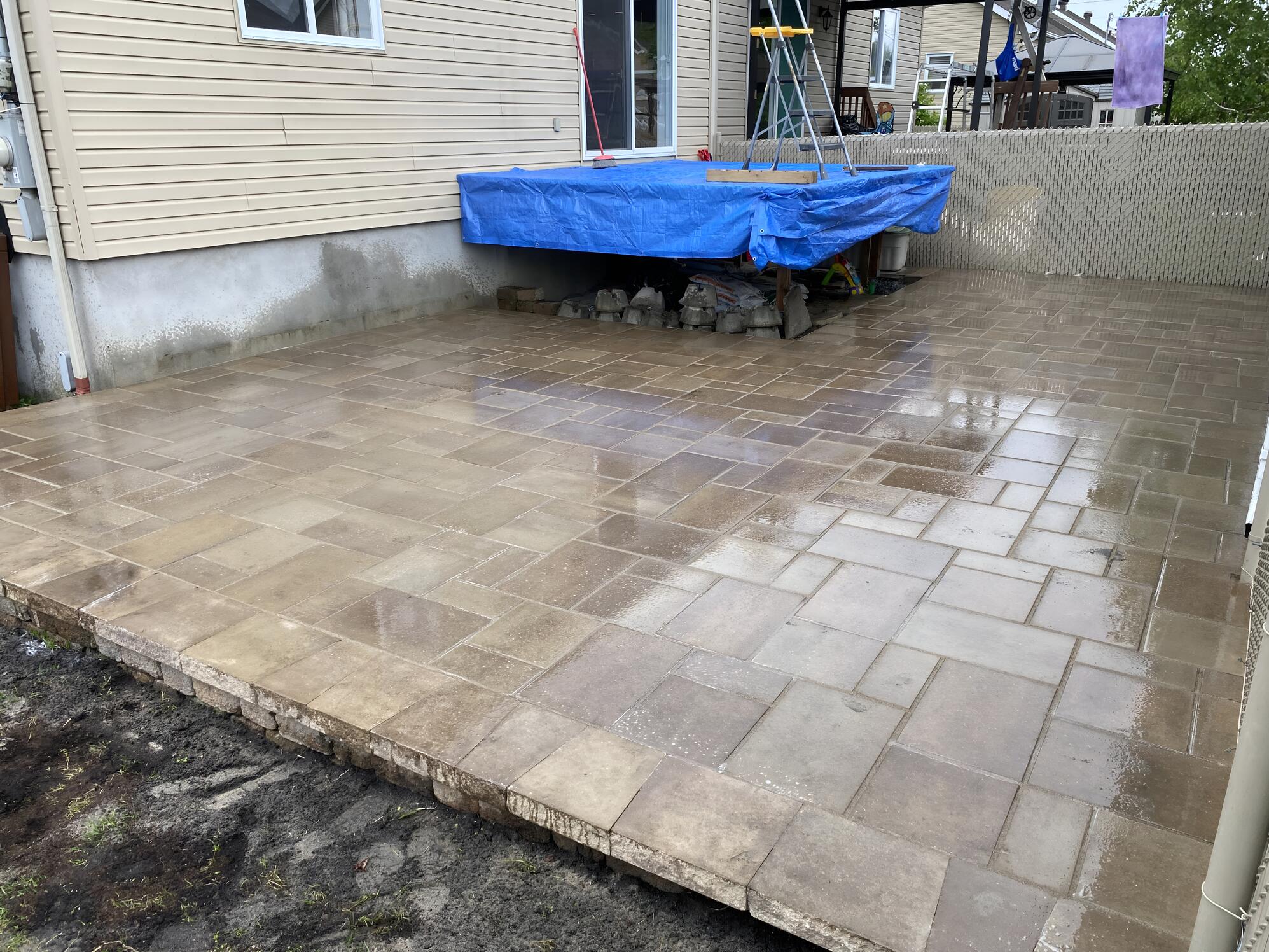 Terrasse en pavé humide après le nettoyage d’une cour résidentielle.