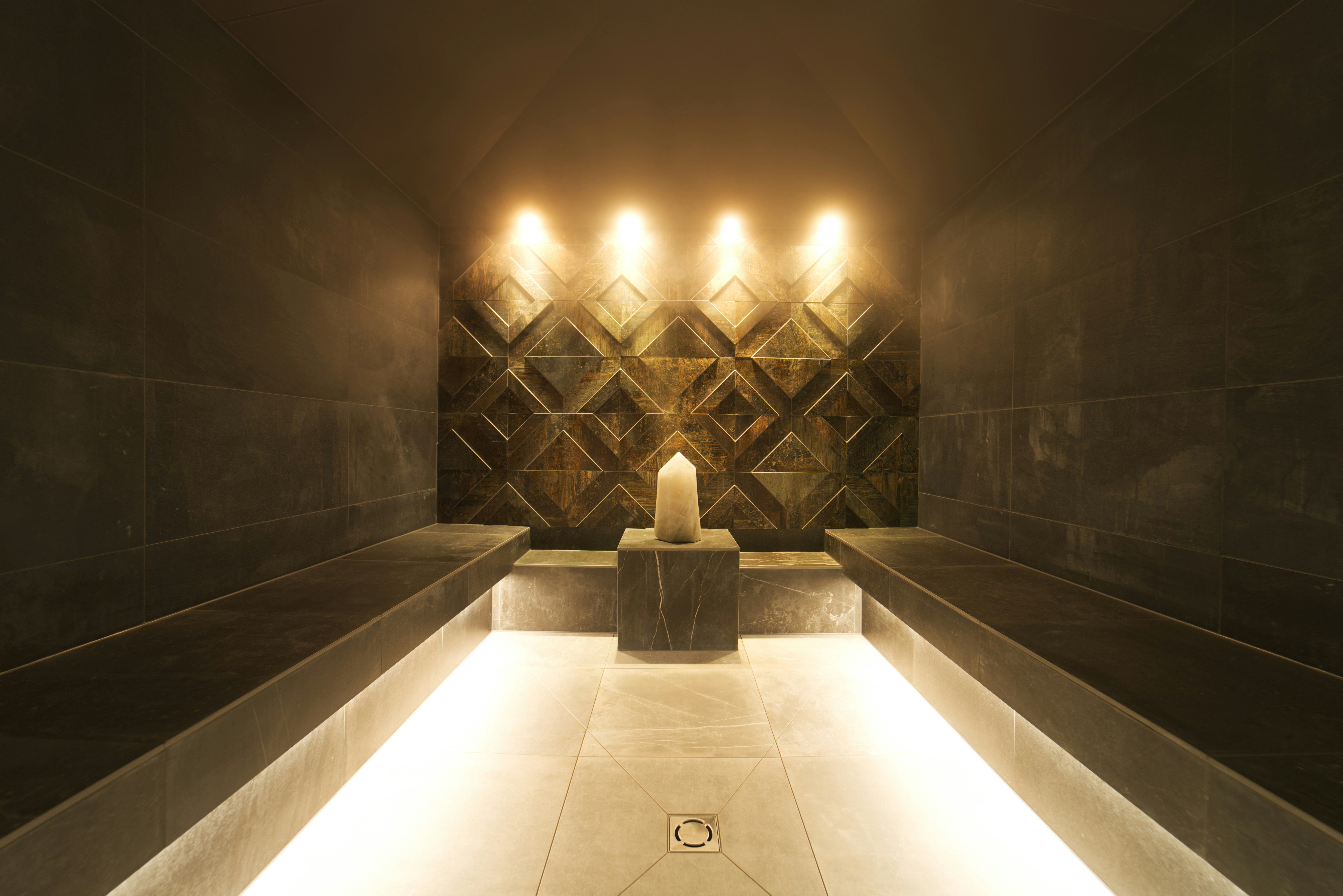 An empty candlelit steam corridor in a spa.