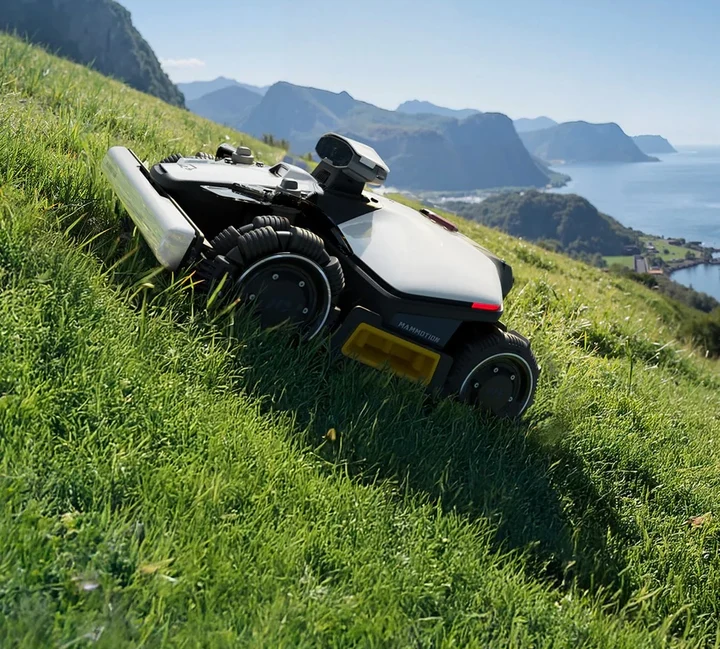 Robotplæneklipper kører på en skrånende græsplæne.