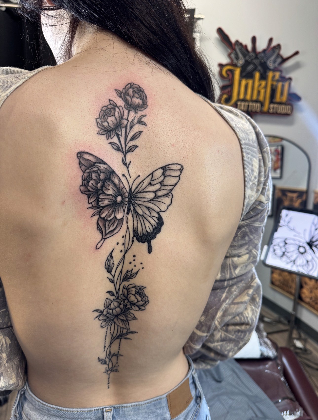 Butterfly and Floral Spine Piece: fine line tattoo on the spine and back, by Meer Rich