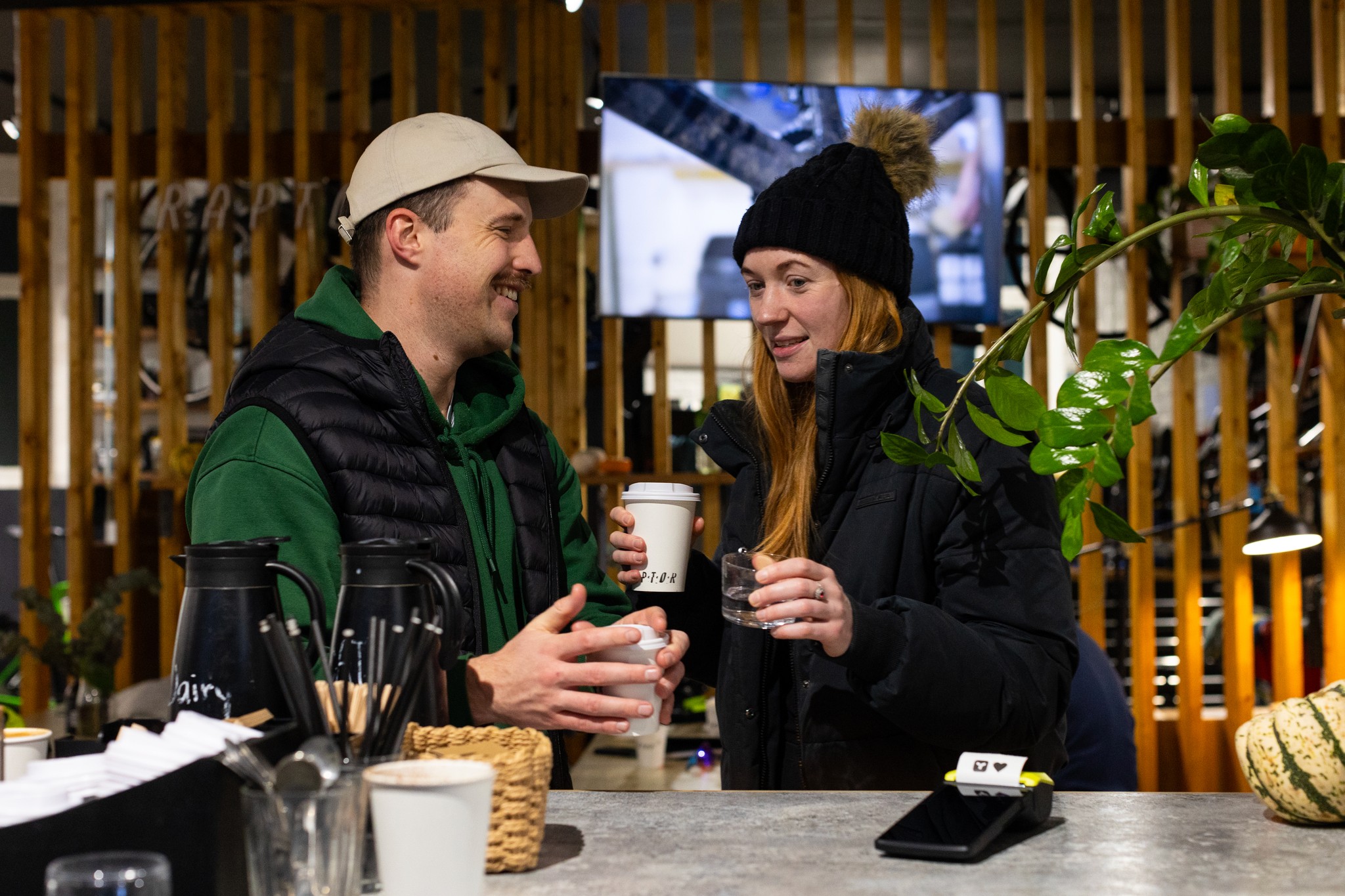 Two people having coffee near a Teya card machine