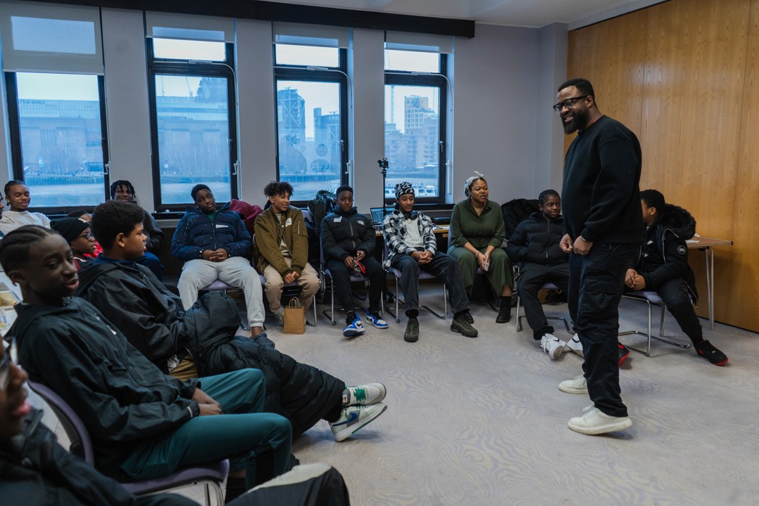 A group of young people sat in a circle listening to a teacher give a workshop at City of London School
