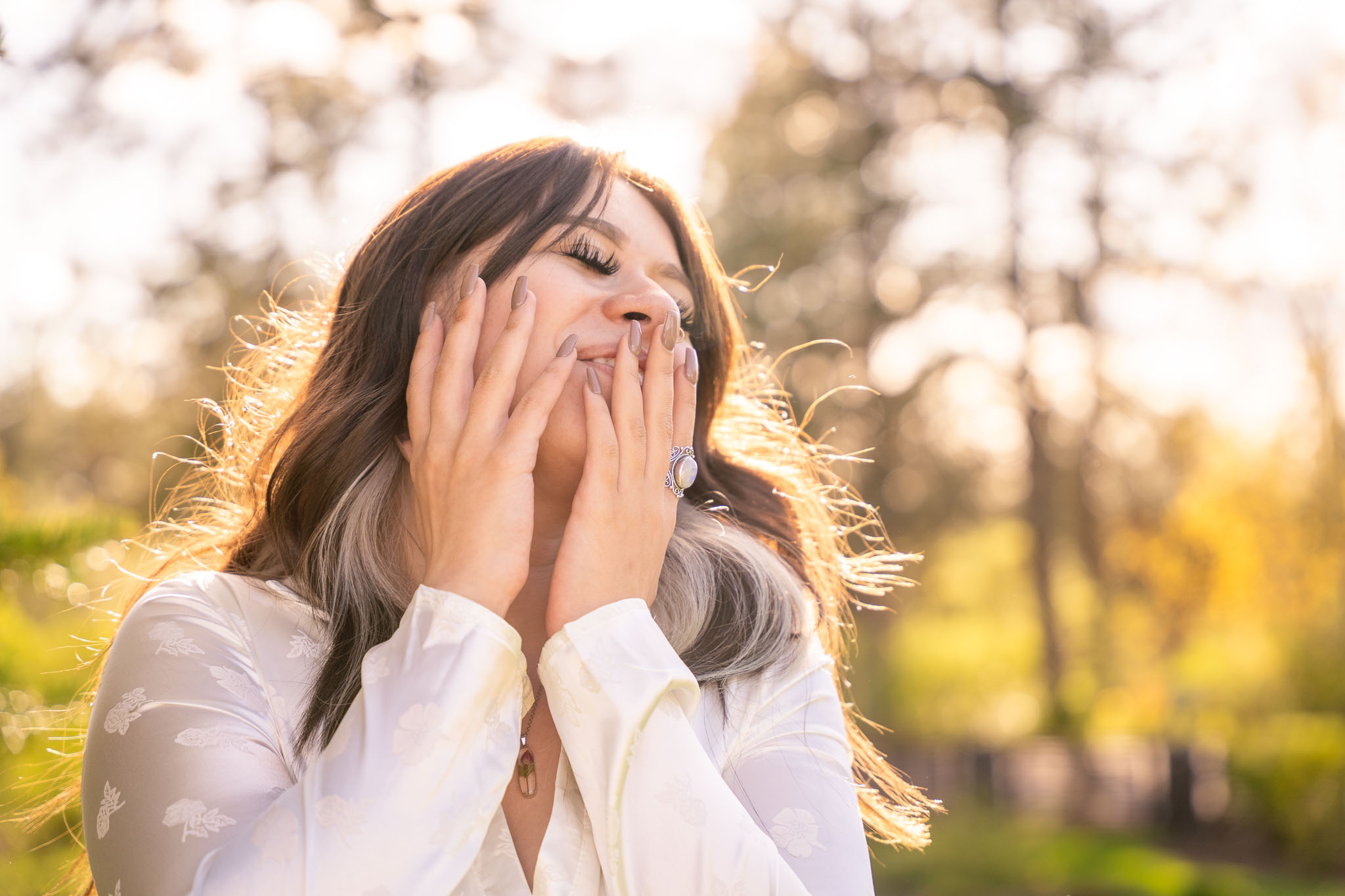 A beautiful portrait of a girl gently holding her face with her eyes closed