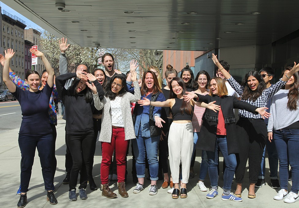 group photo of students and alumni on the sidewalk