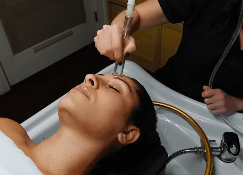 Esthetician using a lymphatic drainage tool on a client