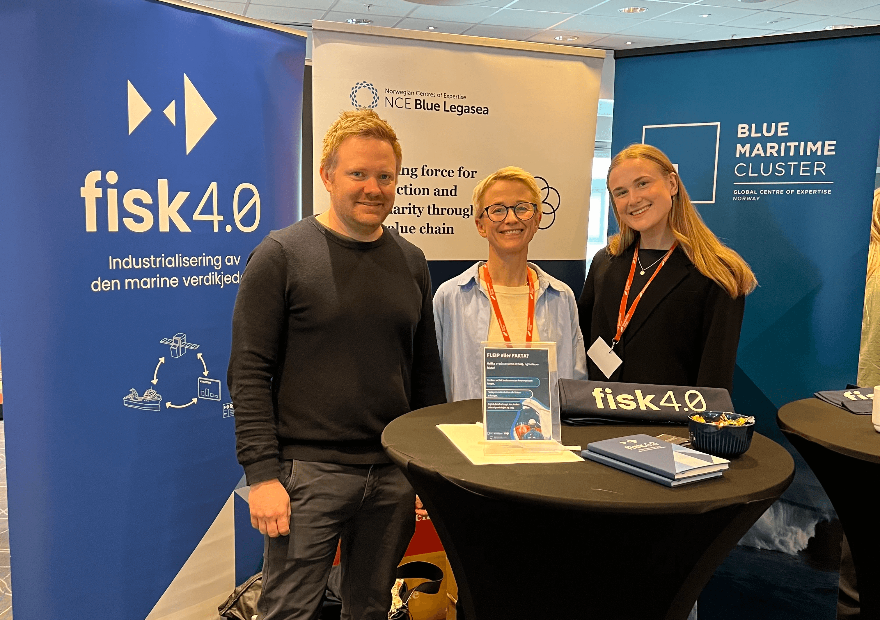 A person wearing a virtual reality headset stands in front of multiple screens, engaged in a digital experience.