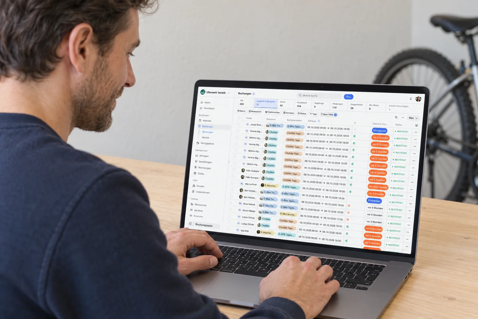 Employee checking bicycle rental bookings on a laptop