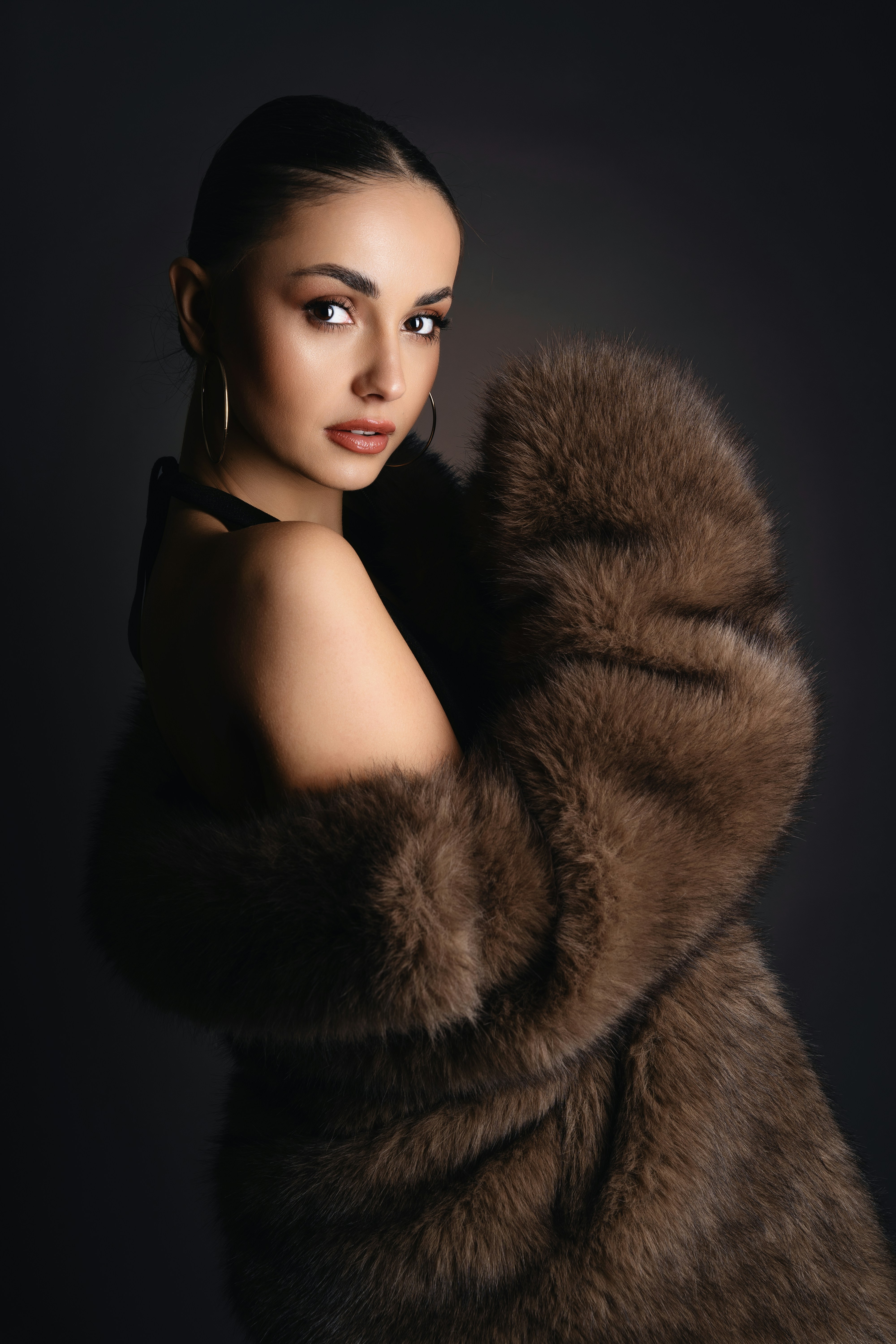 A woman in a fur coat posing for a picture
